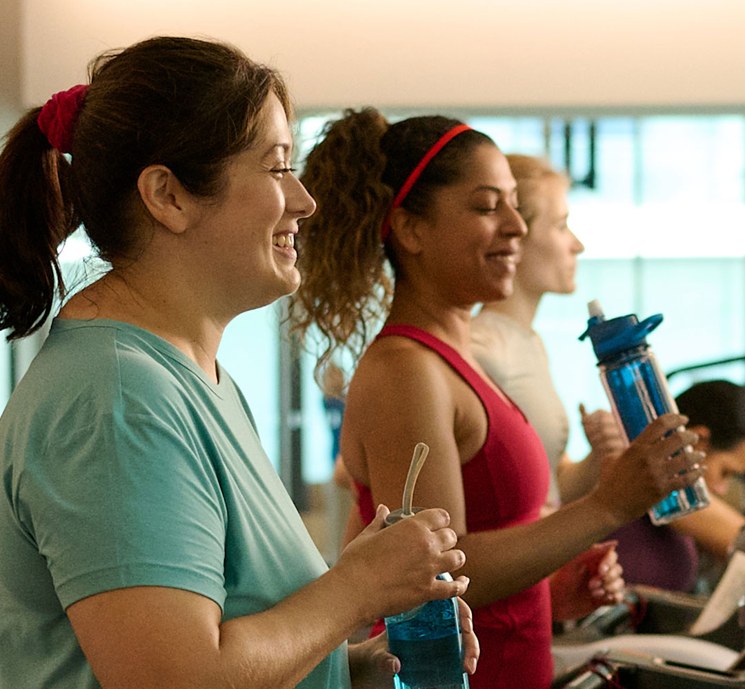 Greater Together 2025 - 00597 (teaser) two women chatting and laughing while walking on treadmills