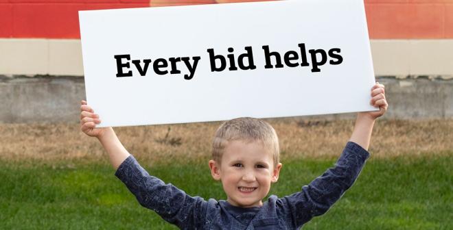 Young boy holding a sign that says "every bid helps"
