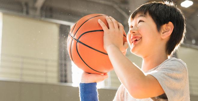 smiling boy preparing to shoot a basketball in the gymnasium