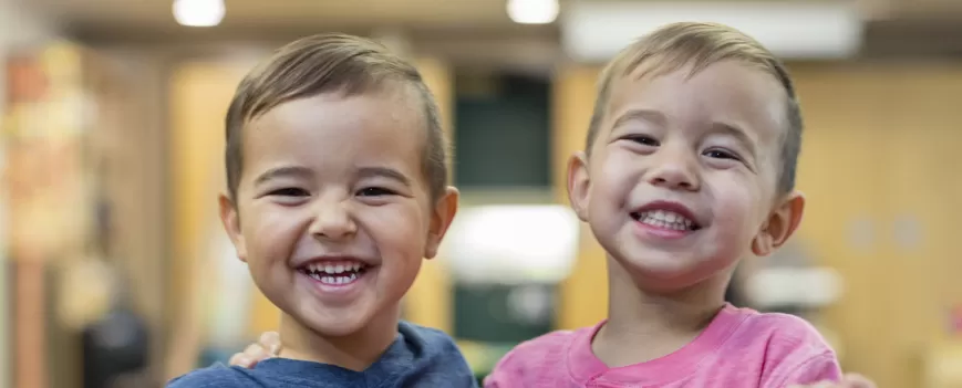 Two 4 year old boys smiling