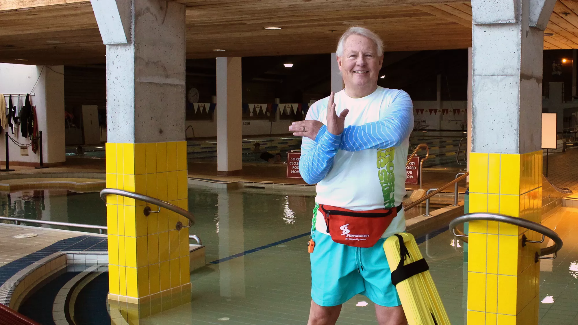 man in lifeguard outfit infront of pool